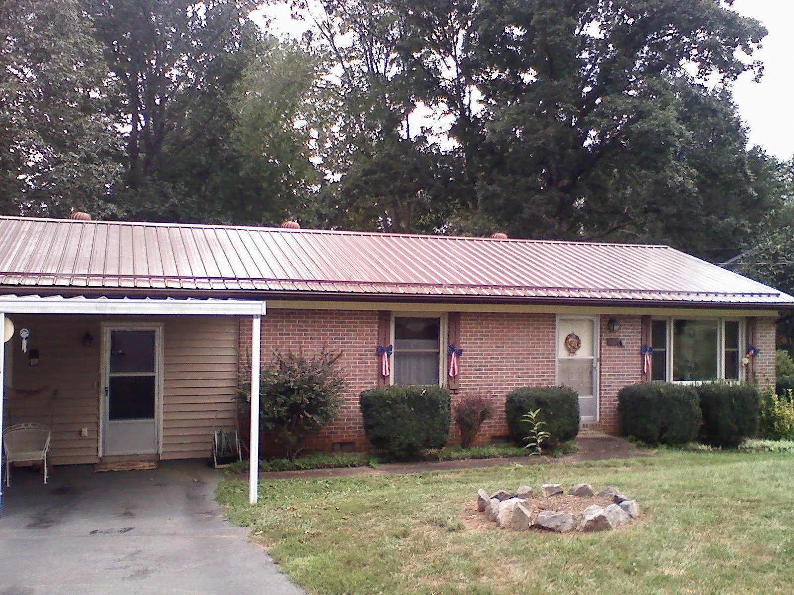 Bronze metal roof and carport on a brick ranch home — Roof Repair work by our crew in Mohrsville